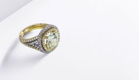 Cushion-cut, fancy yellow diamond surrounded by white and fancy diamonds.