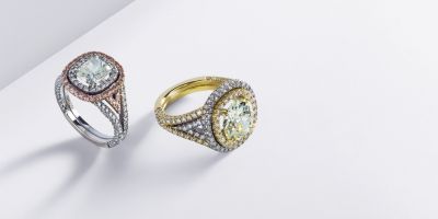 Cushion-cut diamond surrounded with white and fancy diamonds.